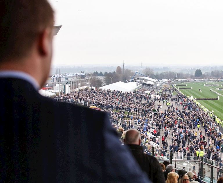 A man looking over the racecourse from a grandstand